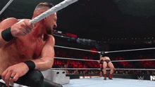 a wrestler in a wrestling ring with the word nxt on the wall