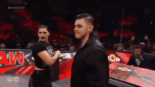 a man and a woman are standing in a wrestling ring .