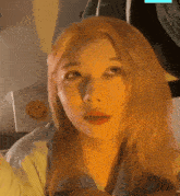 a woman with blonde hair looks at the camera in front of a smiley face