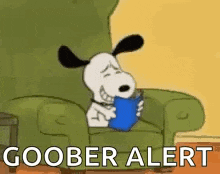 snoopy is sitting in a chair reading a book and saying goober alert .