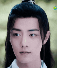 a close up of a young man with long hair