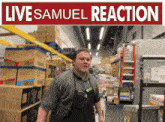 a man in an apron stands in a warehouse under a live samuel reaction sign