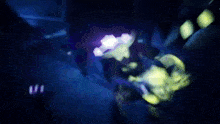 a shark is swimming in a dark aquarium with a purple light shining on it .