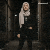 a woman in a hijab is squatting on the ground
