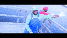 two men dressed as mario and luigi standing on a bridge