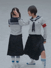two girls in school uniforms are standing next to each other with one wearing socks with chinese writing on them