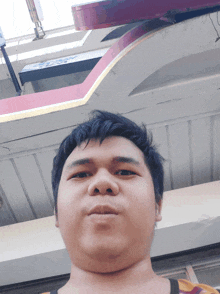 a man taking a selfie with a sign in the background that says ' a '