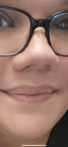a close up of a woman 's face with glasses on .