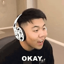 a man wearing headphones is making a funny face and says `` okay '' .