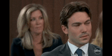 a man in a suit and tie is sitting in front of a woman .
