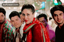 a woman in a red dress is standing in front of a group of men .