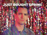 a man is standing in front of a curtain with the words just bought spring written above him