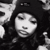 a black and white photo of a girl wearing a beanie with the song feel it young thug on the bottom right