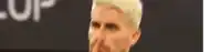 a blurry picture of a man covering his mouth with his hand .