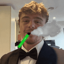 a man in a tuxedo smoking a green elf device