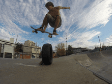 a skateboarder is doing a trick with a tire in the foreground