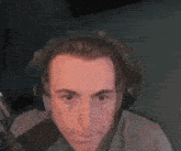 a man is wearing headphones and making a funny face .