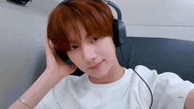 a young man wearing headphones and a white shirt with the word honey on the arm