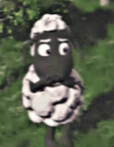 a cartoon sheep with big eyes standing in the grass .
