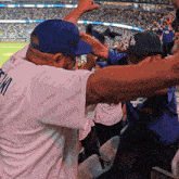 a man wearing a la hat and a white shirt with the word tim on the back
