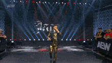 a man in a suit and tie is standing in front of an aew logo
