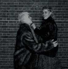 a black and white photo of two people hugging each other