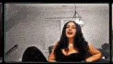 a woman is sitting on a couch in a living room laughing .