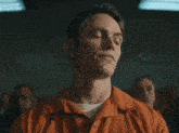 a man in an orange prison uniform looks up at the sky