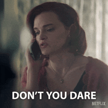a woman talking on a cell phone with a netflix logo behind her