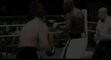 two men are fighting in a boxing ring with a crowd in the background