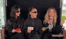three women are sitting in a chair and one has a sign that says video valleyview