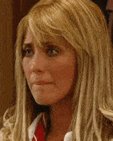 a woman with blonde hair and blue eyes is crying