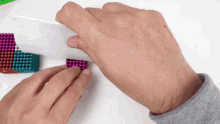 a person is playing with a bunch of colorful magnetic balls
