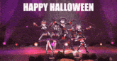 a group of witches are dancing on a stage with the words happy halloween written above them