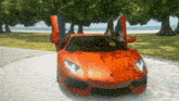 an orange sports car with the doors open is parked on the side of a road