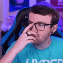 a man wearing glasses and a blue shirt with the word limited on it .