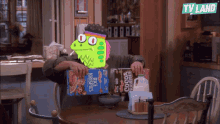 a man is sitting at a table with a box of kellogg 's rice krispies cereal