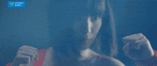 a woman in a red top is standing in front of a blue sign that says upfront works