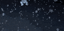 a man smoking a cigarette with snowflakes behind him