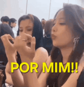 two women are making a heart shape with their hands and the words por mim are above them