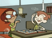 a cartoon of a boy and a girl sitting at a desk with a book on it .