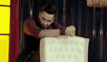 a man wearing a watch is leaning on a chair