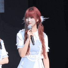 a woman with red hair is holding a microphone in her hand