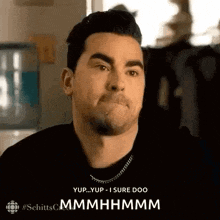 a man is making a funny face while wearing a necklace .