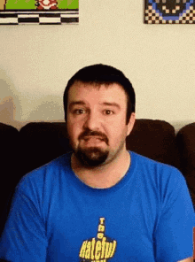 a man with a beard is wearing a blue shirt that says hateful on it
