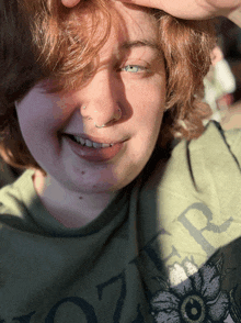a young woman wearing a green shirt that says ' oztr ' on it