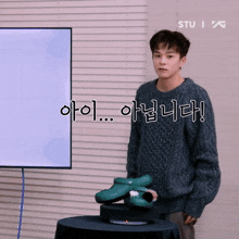 a man in a grey sweater stands in front of a white board that says stu on it