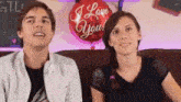 a man and a woman are sitting next to each other with a red balloon that says i love you
