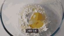 a glass bowl filled with flour and an egg with a label that says ' 1 ' on it