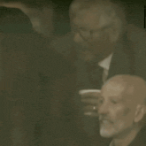 a man in a suit and tie is pointing at another man in a suit and tie